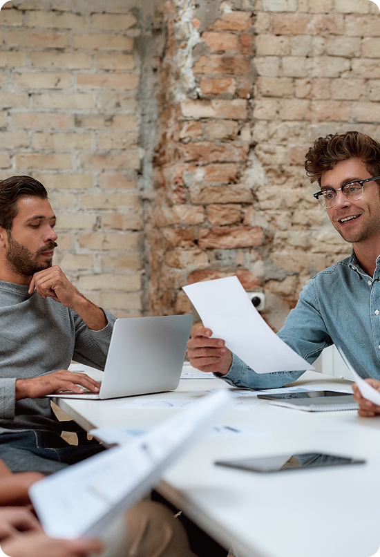 Equipo de trabajo analizando documentos y datos en una oficina de estilo industrial