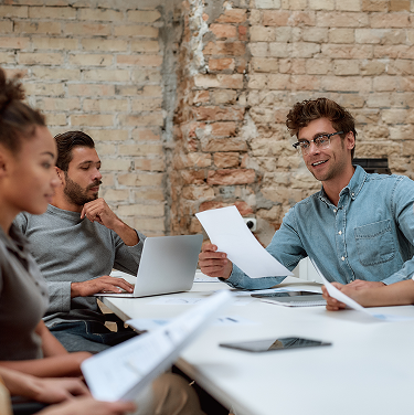 equipo de trabajo analizando documentos y datos en una oficina de estilo industrial