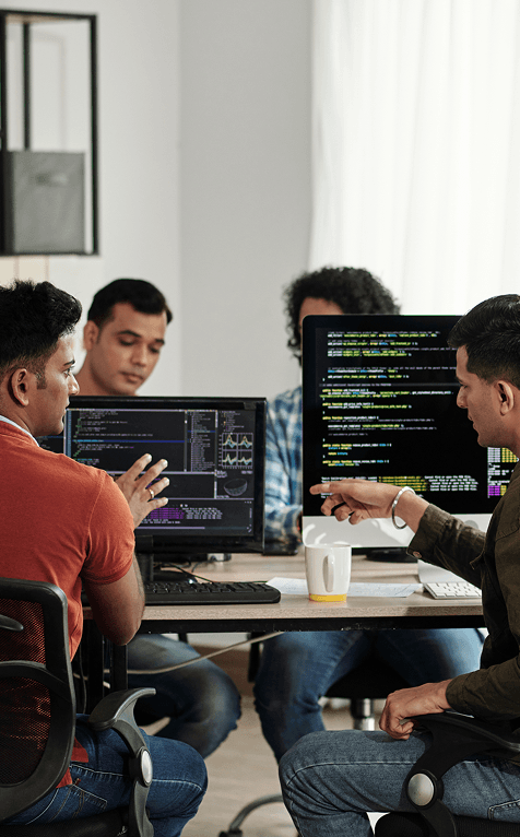 equipo de especialistas analizando y discutiendo líneas de código en monitores