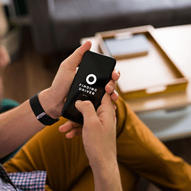 Primer plano de unas manos sosteniendo y tocando la pantalla de un smartphone negro