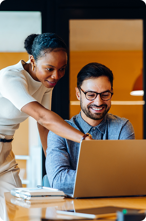 dos profesionales colaborando frente a una computadora portátil en un espacio de trabajo moderno