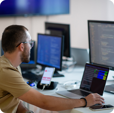 especialista en IT supervisando sistemas de software en múltiples pantallas