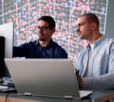 dos hombres de negocios analizando gráficos de datos técnicos complejos en una pantalla grande de la oficina